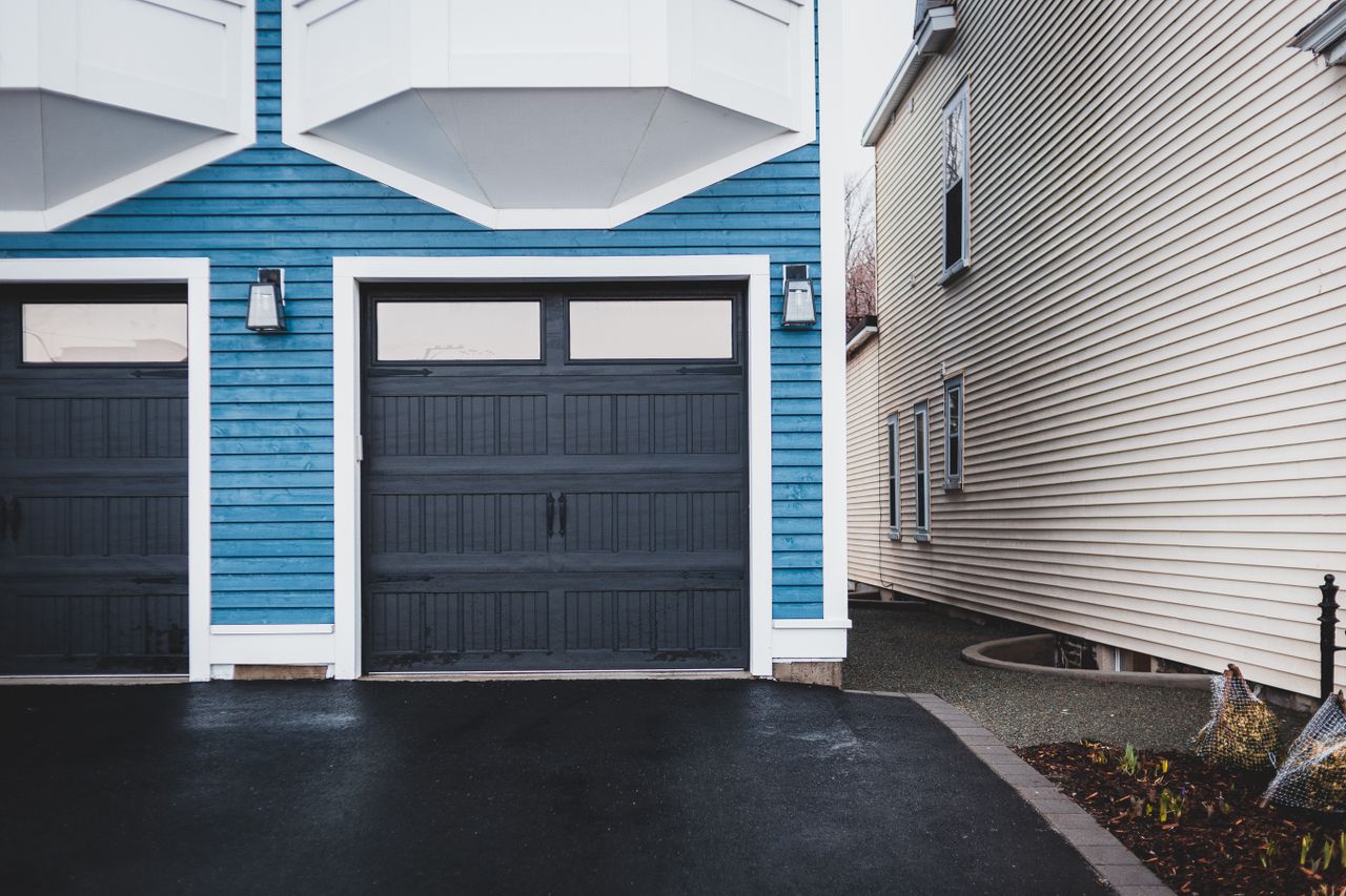 Home Exterior of contemporary residential building with wooden door and walls paneled blue and lights